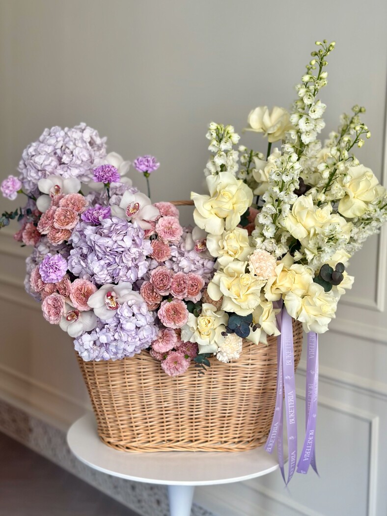 Decorative arrangement of cream garden roses and light yellow delphiniums