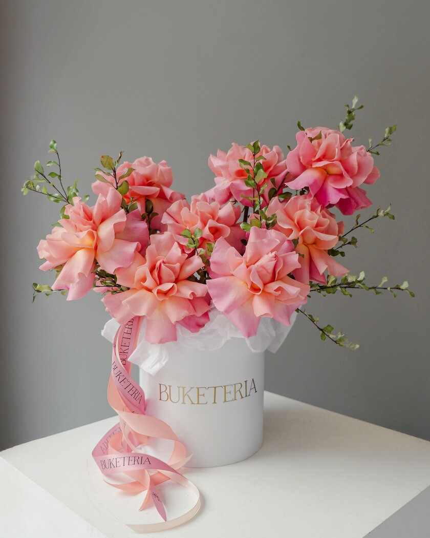 Peach garden roses with curly willow in a decorative composition