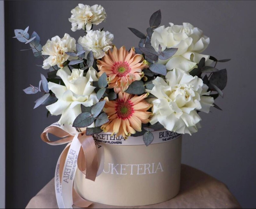 Three white garden roses with peach gerberas and cream carnations