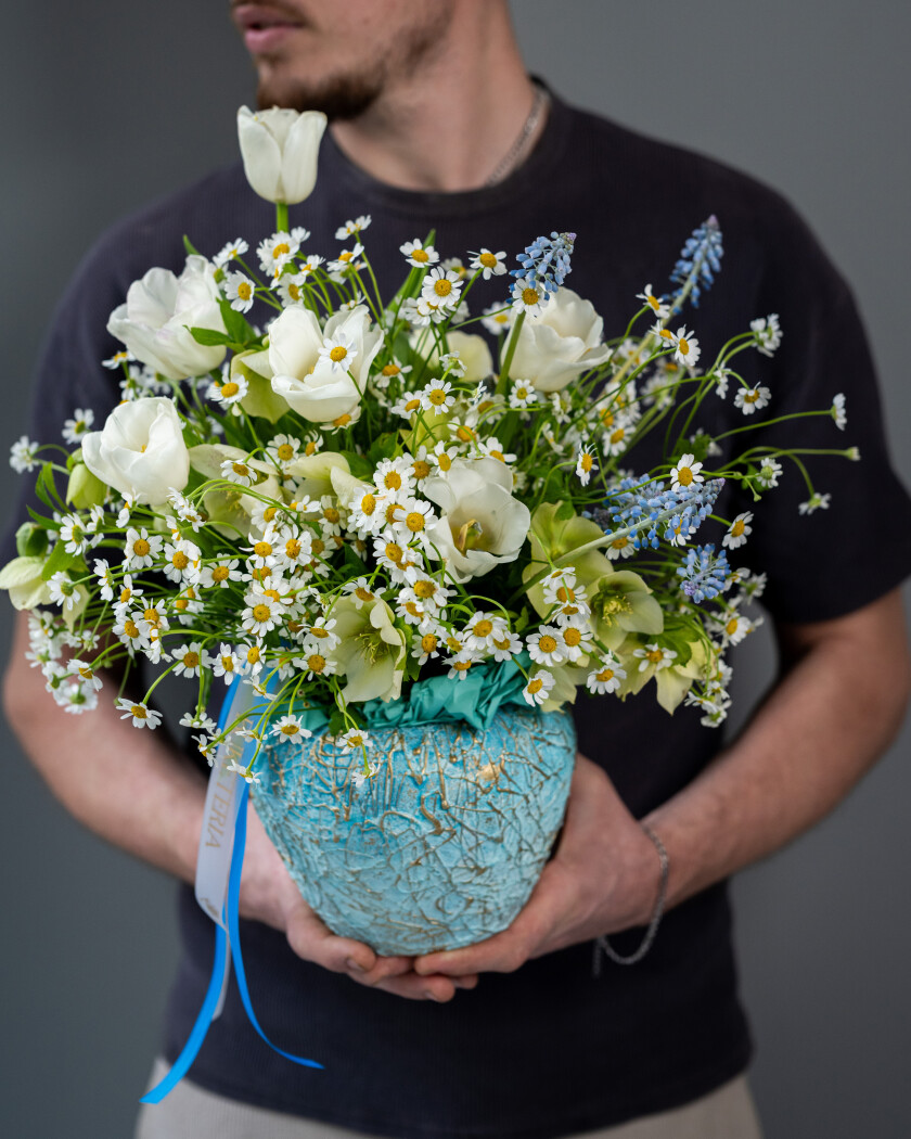 Spring bouquet of white tulips, cream hellebores, and light blue muscari