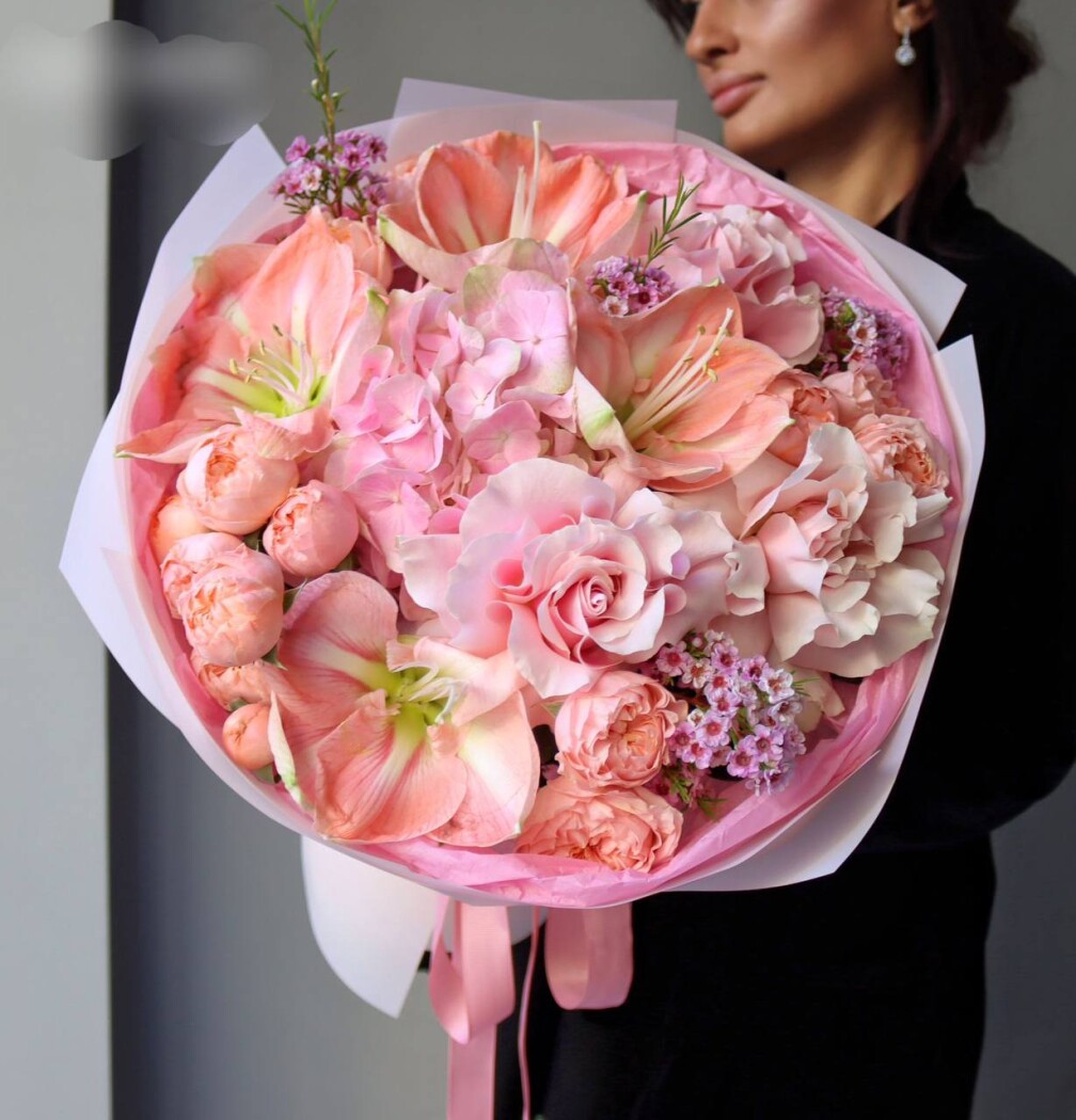 Two salmon amaryllis with peach and blush roses
