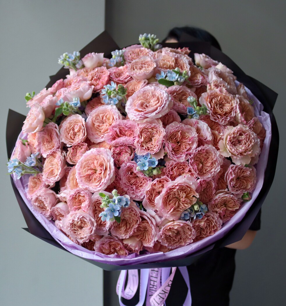 Peach spray roses with light blue tweedia