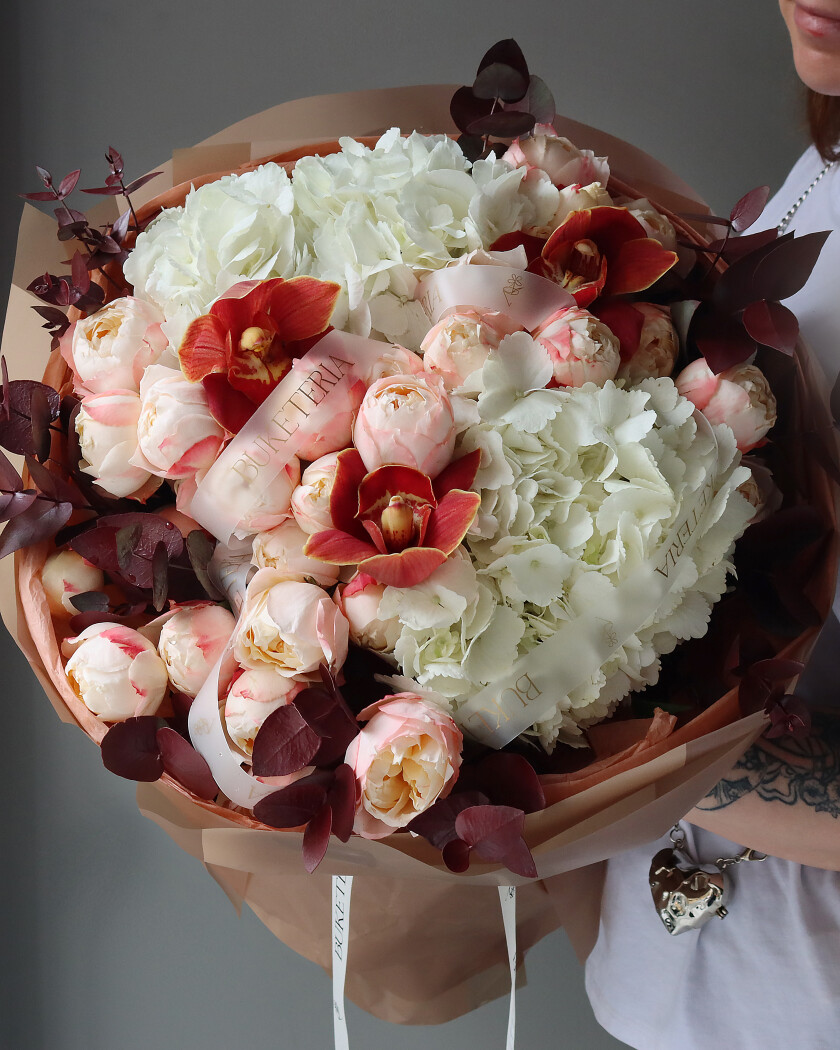 Peach spray roses with white hydrangeas and red cymbidium orchids