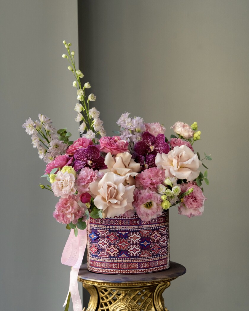 Decorative composition of purple vanda orchids and blush garden roses