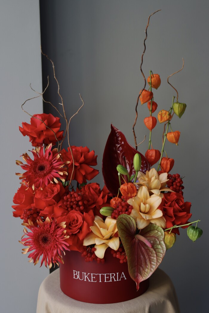 Seven red hybrid tea roses with orange physalis and burgundy anthurium