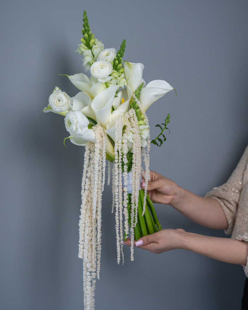 Eleven white callas with cream ranunculus and light green snapdragons