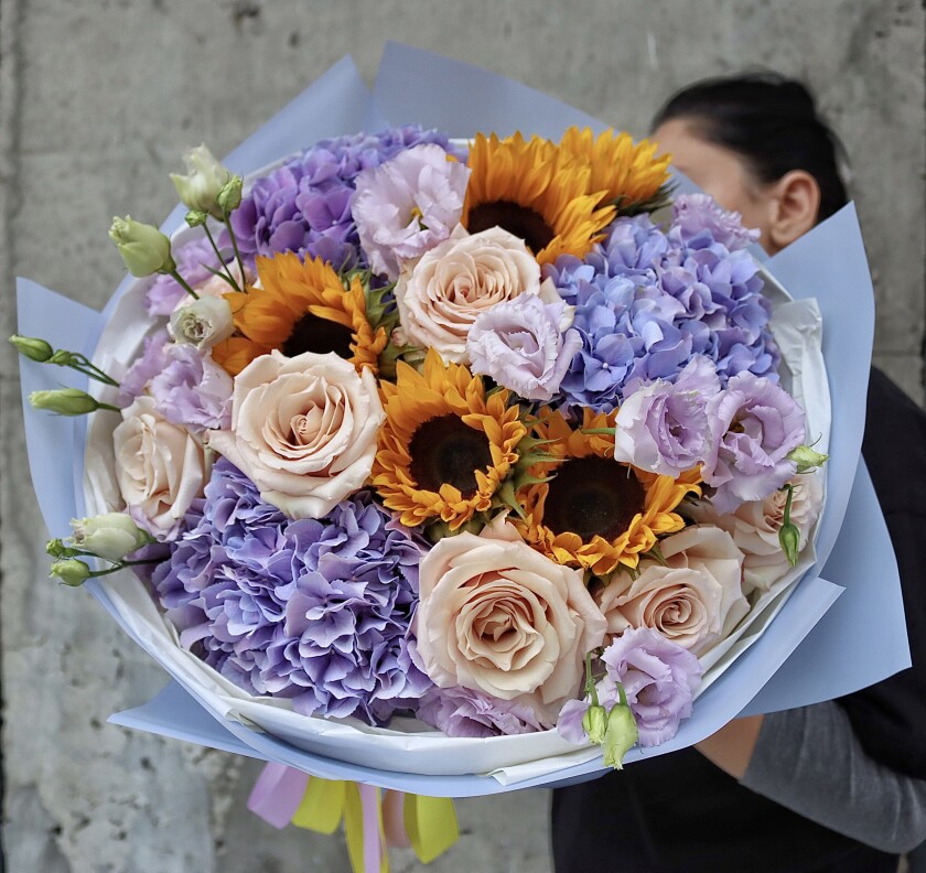 Mixed bouquet of peach garden roses, lilac hydrangeas, and yellow sunflowers