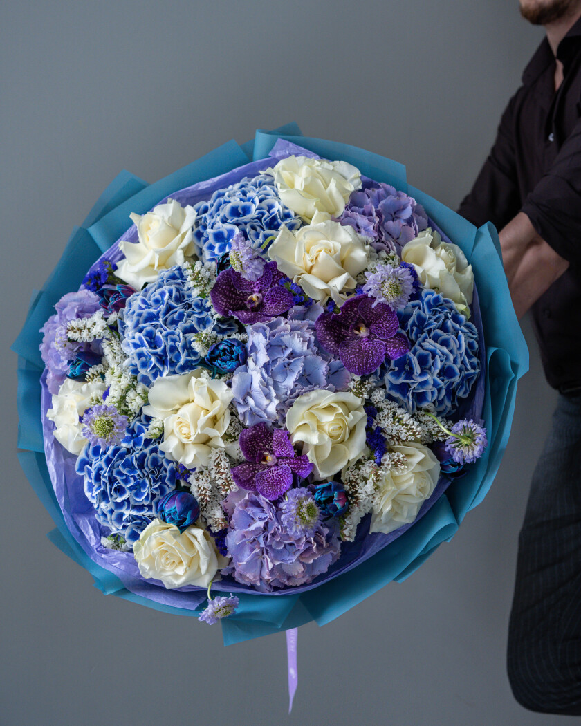 Mixed bouquet of blue hydrangeas and cream garden roses