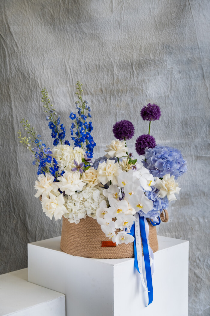 White phalaenopsis orchids with blue delphiniums and cream hydrangeas