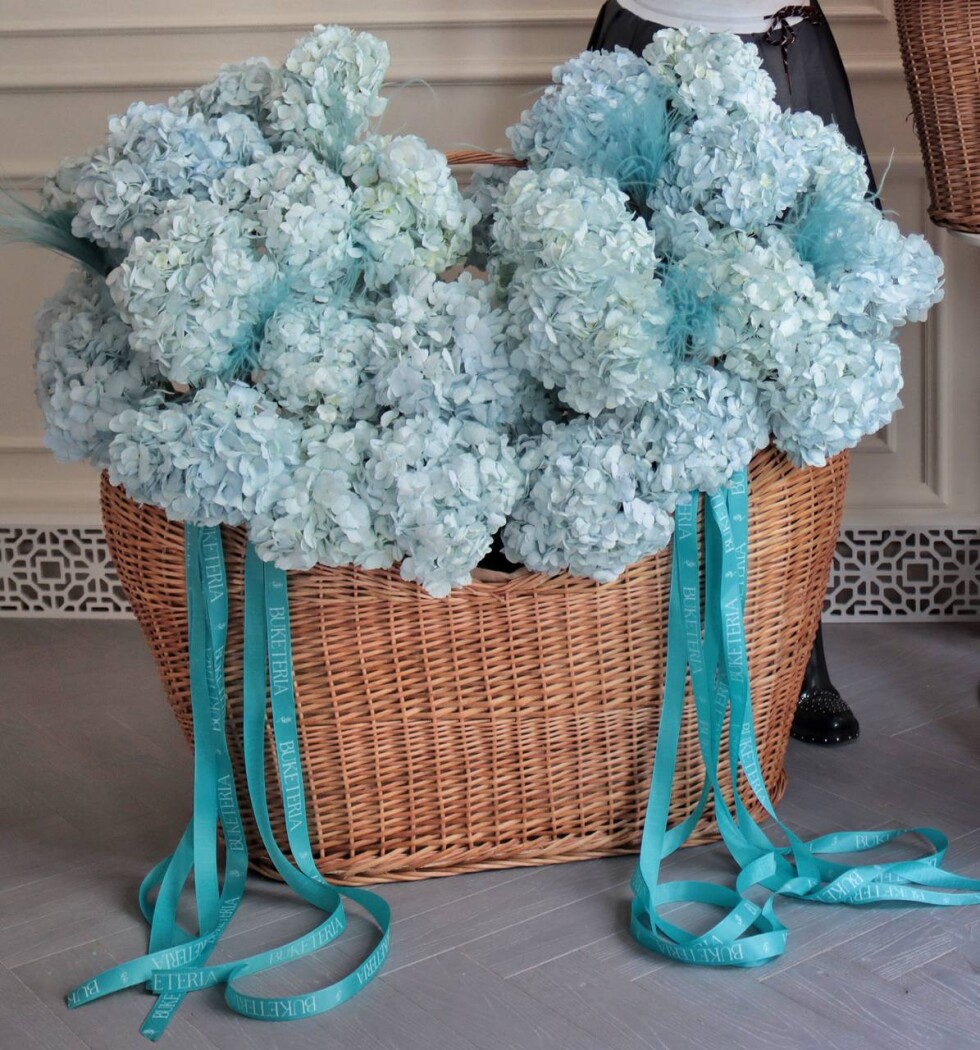 Decorative arrangement of light blue hydrangeas in a basket