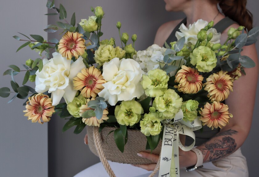 Cheerful decorative arrangement of light green lisianthus and orange gerberas