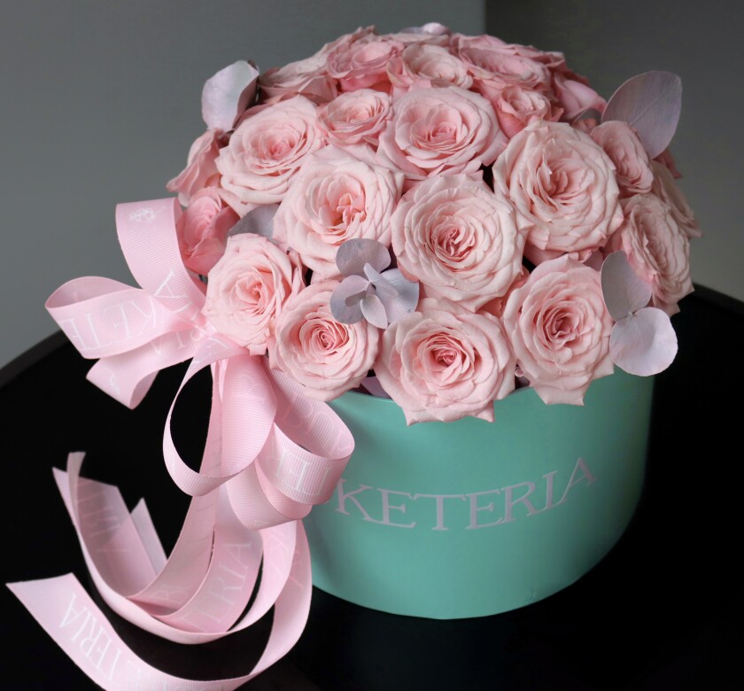 Seven light pink spray roses in a decorative arrangement