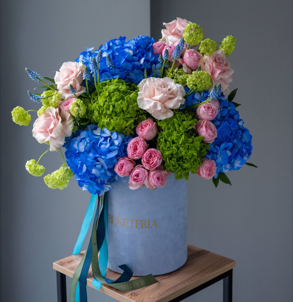 Decorative composition of blue hydrangeas and blush garden roses
