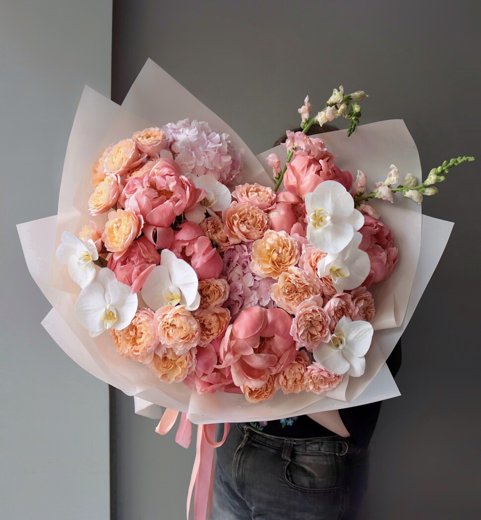 Coral peonies with peach spray roses and white orchids