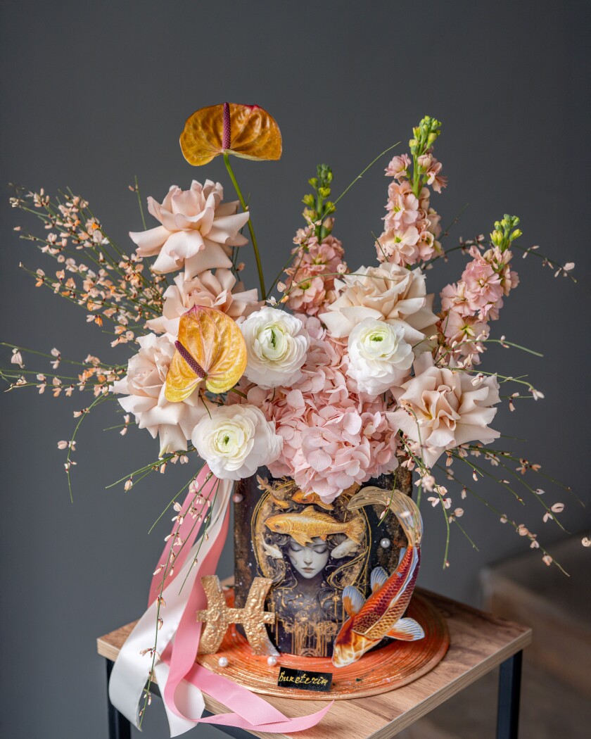 Decorative composition of peach garden roses and gold anthuriums in an art box
