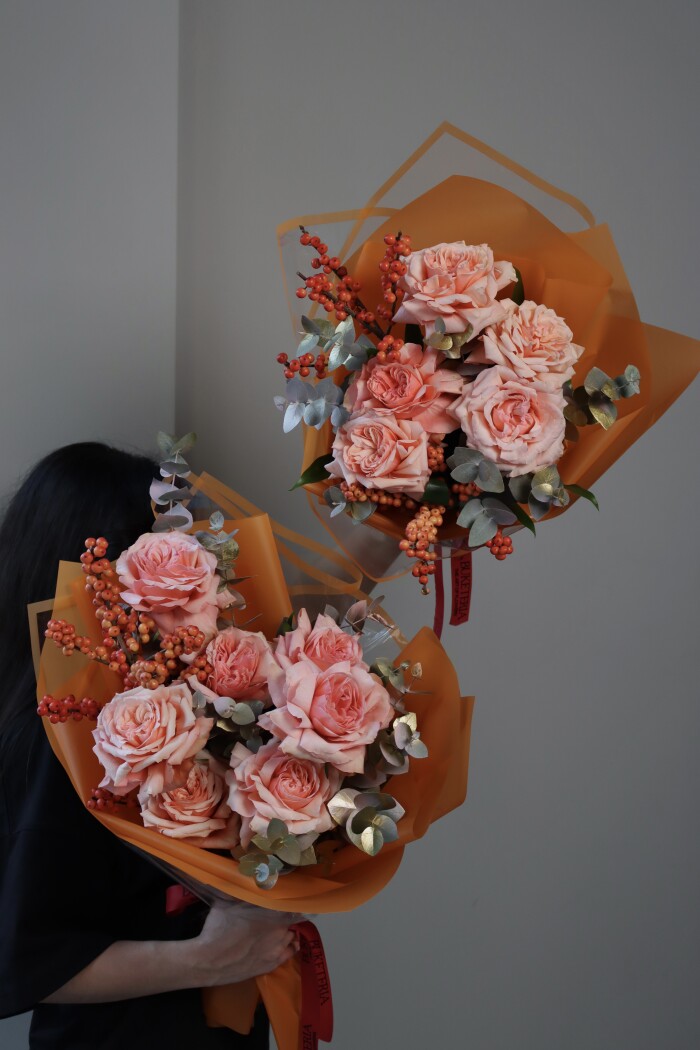 Peach garden roses with eucalyptus and red berries