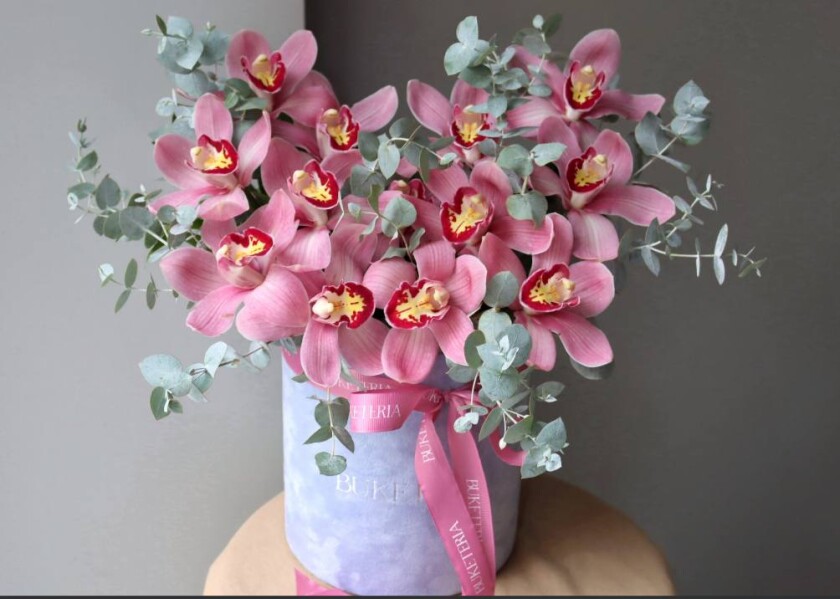 Decorative composition of pink cymbidium orchids in a box