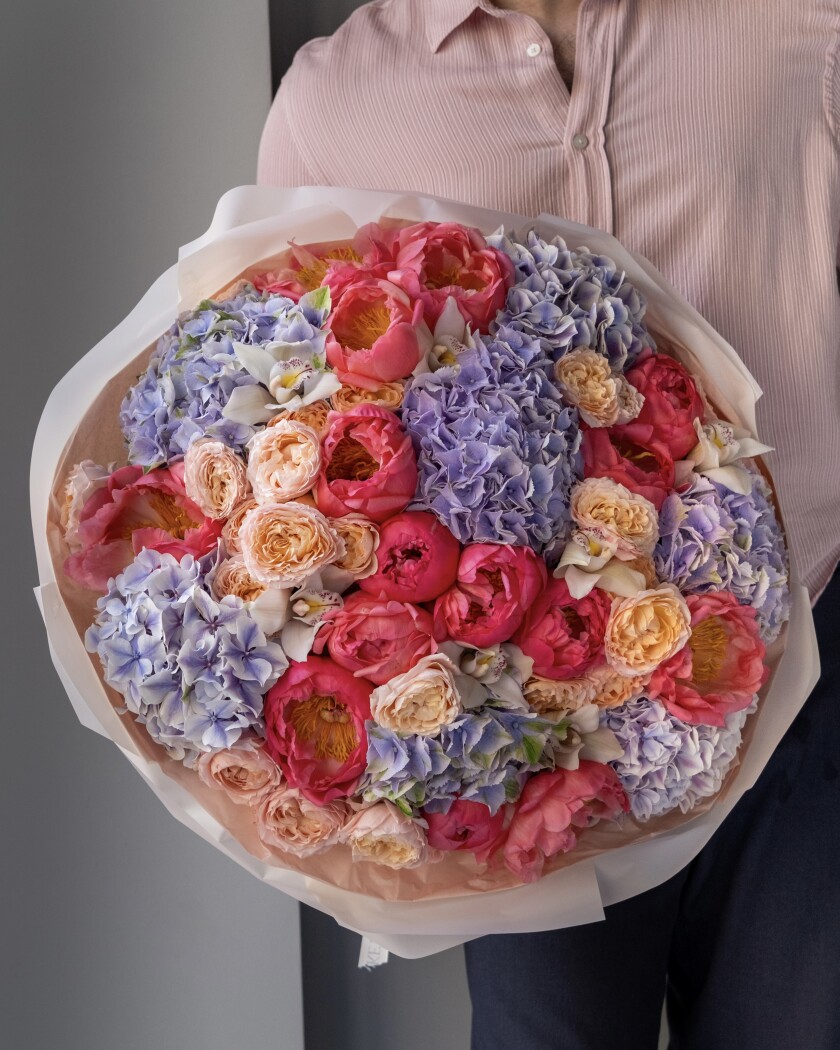 Nineteen coral peonies with lilac hydrangeas and peach garden roses