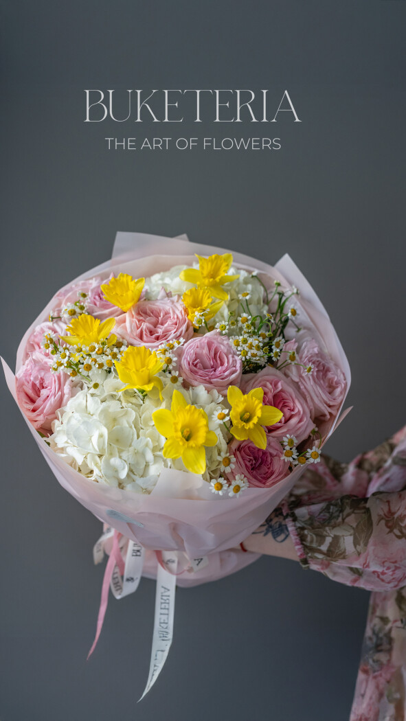 Spring bouquet of white hydrangeas, yellow narcissus, and light pink garden roses