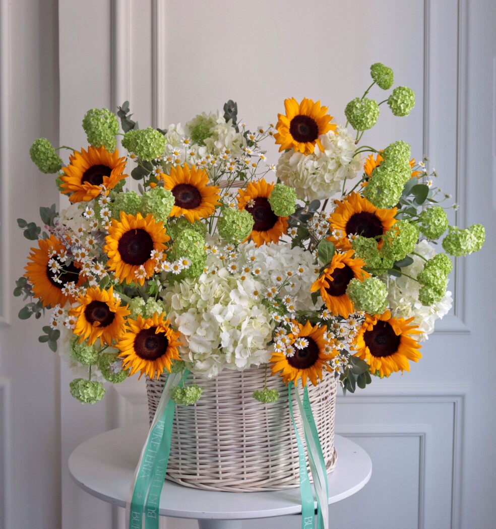Cheerful summer composition of orange sunflowers and white hydrangeas