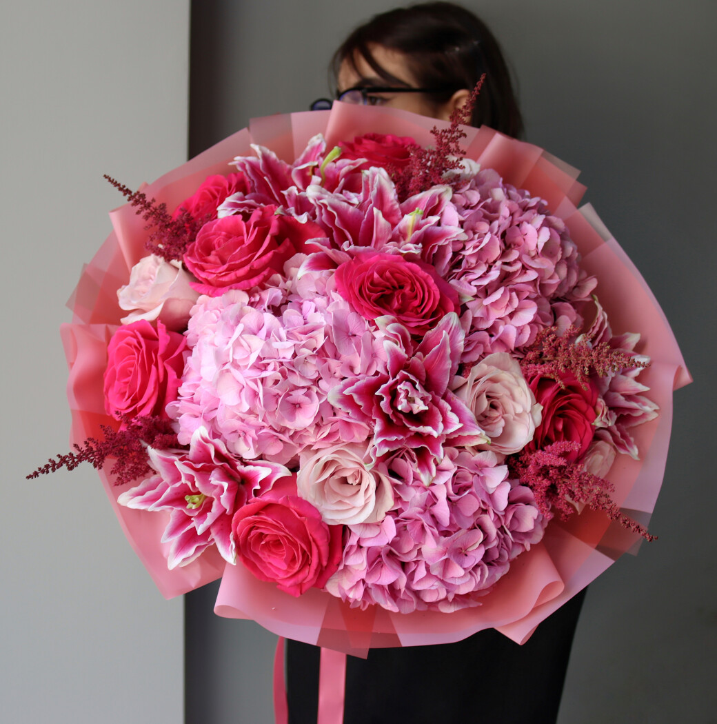 Twelve hot pink garden roses with pink hydrangeas and light pink lilies