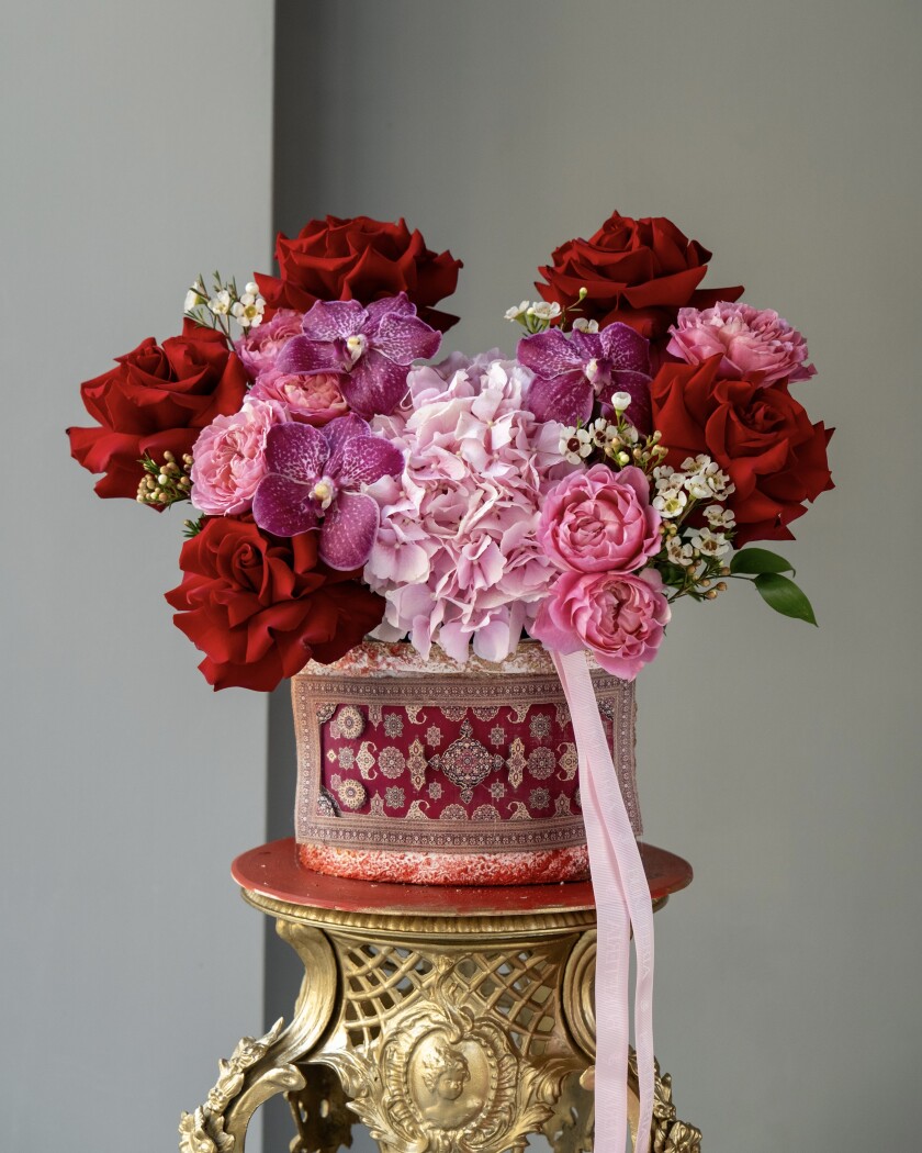 Decorative composition of red hybrid tea roses and lavender vanda orchids