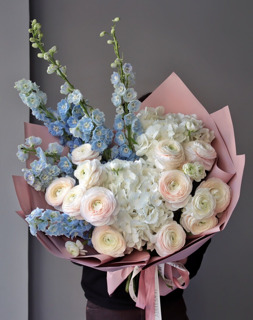 Blush ranunculus with light blue delphiniums and white hydrangeas