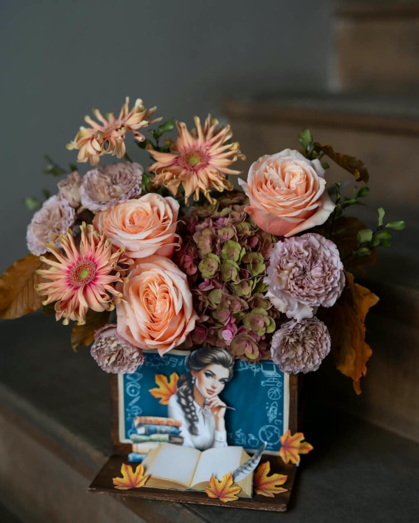 Decorative composition of pink gerberas and peach garden roses in an art box