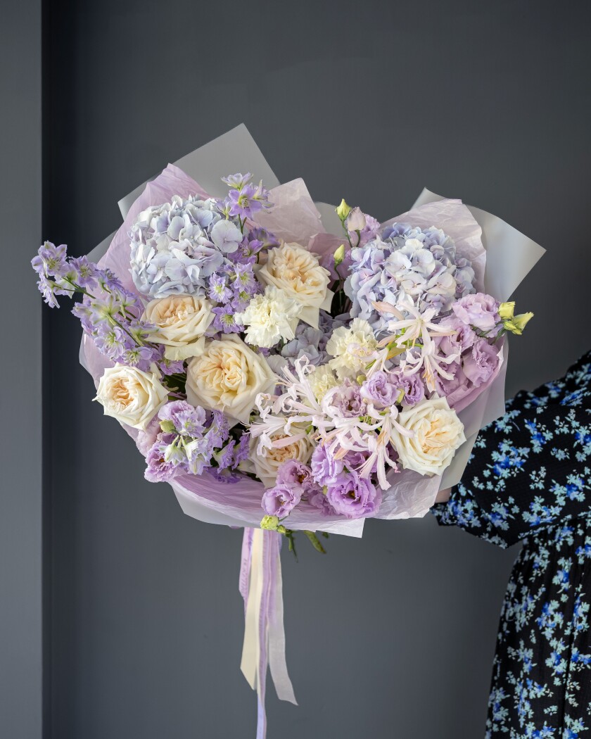 Three blue hydrangeas with light blue delphiniums and cream garden roses