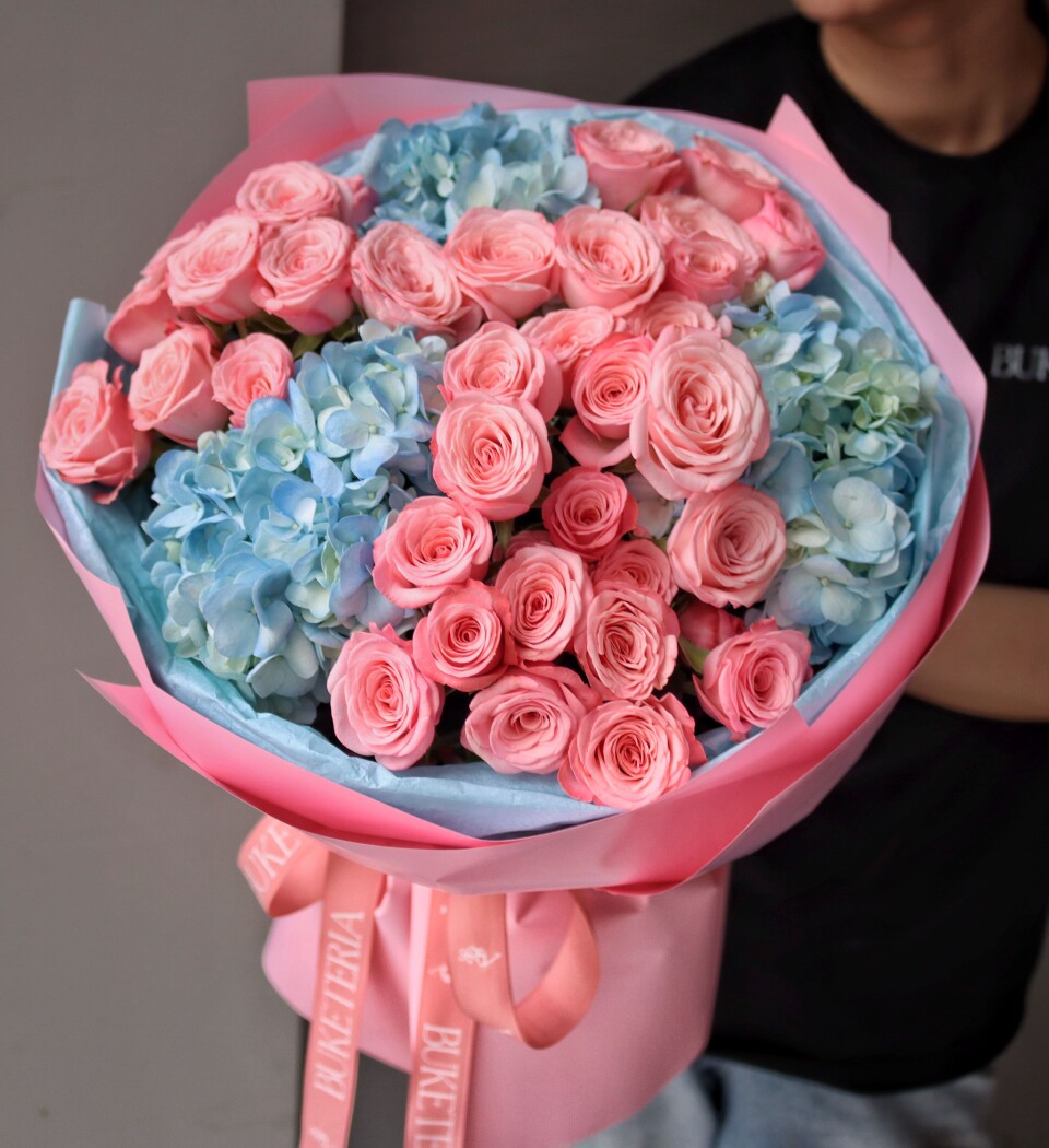 Nine light pink spray roses with blue hydrangeas