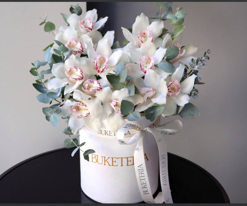Decorative composition of white cymbidium orchids in a box