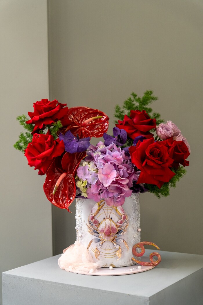 Five red hybrid tea roses with red anthuriums and purple orchids