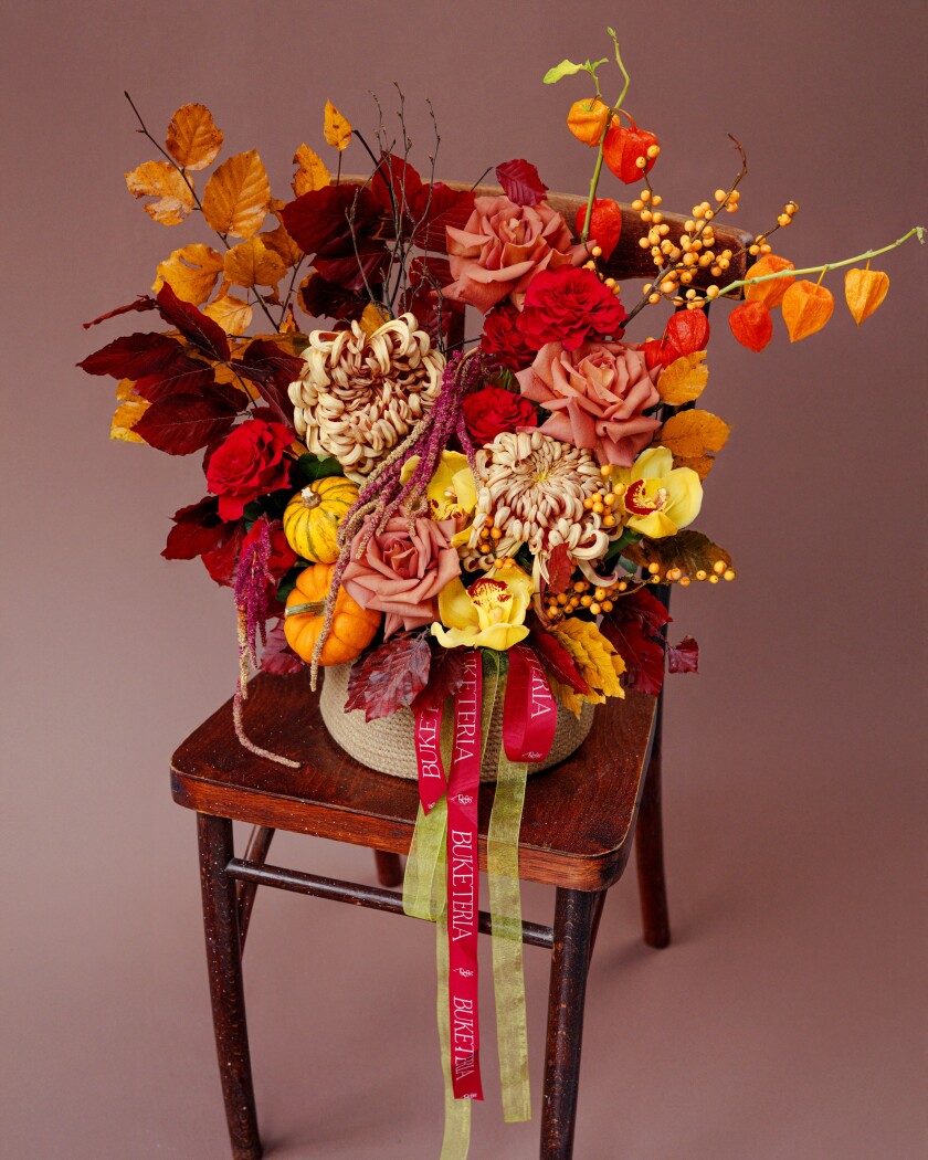 Two burgundy pompon chrysanthemums and three dusty pink garden roses