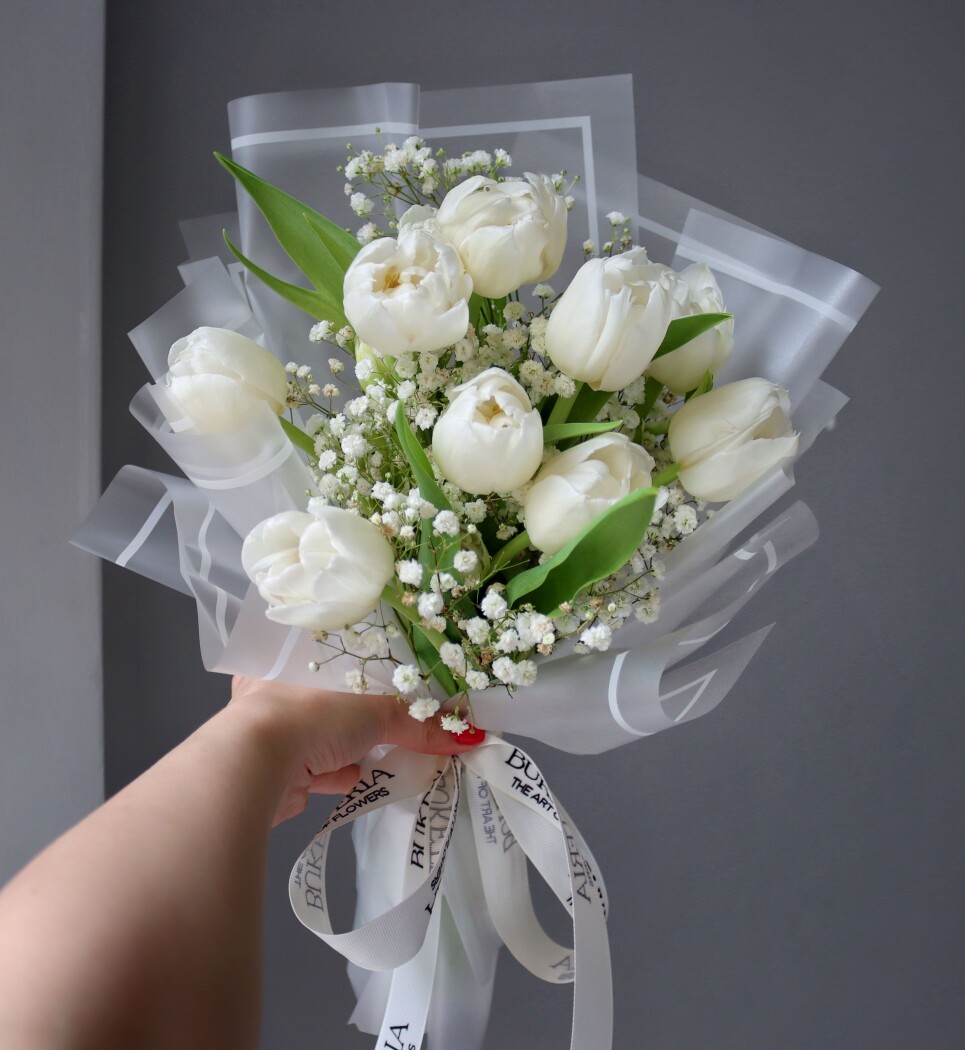 Nine white tulips in a modern round bouquet