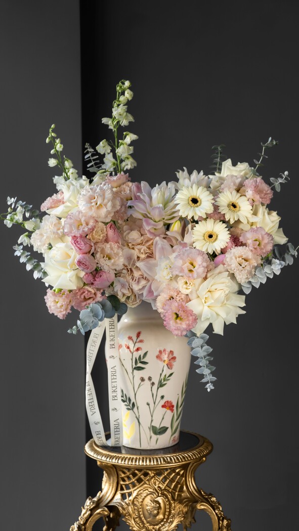 Five dusty pink hybrid tea roses with white delphiniums and blush garden roses