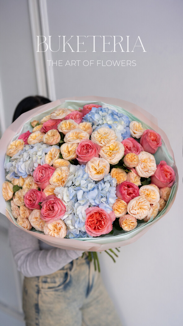 Peach garden roses with coral spray roses and light blue hydrangeas