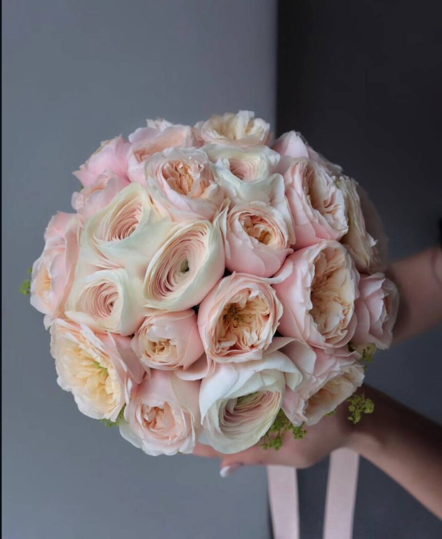 Peach ranunculus with light pink spray roses