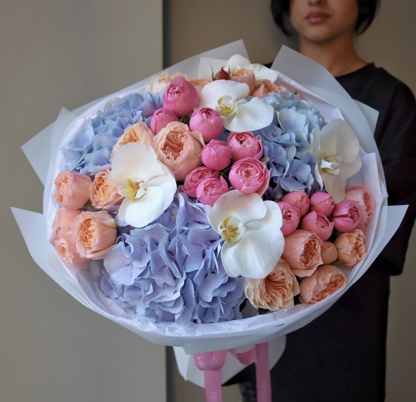 Ten peach garden roses with blue hydrangeas and pink spray roses