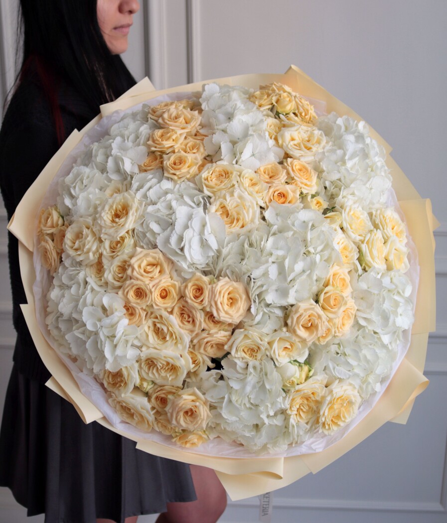 Nine white hydrangeas with fifteen peach spray roses