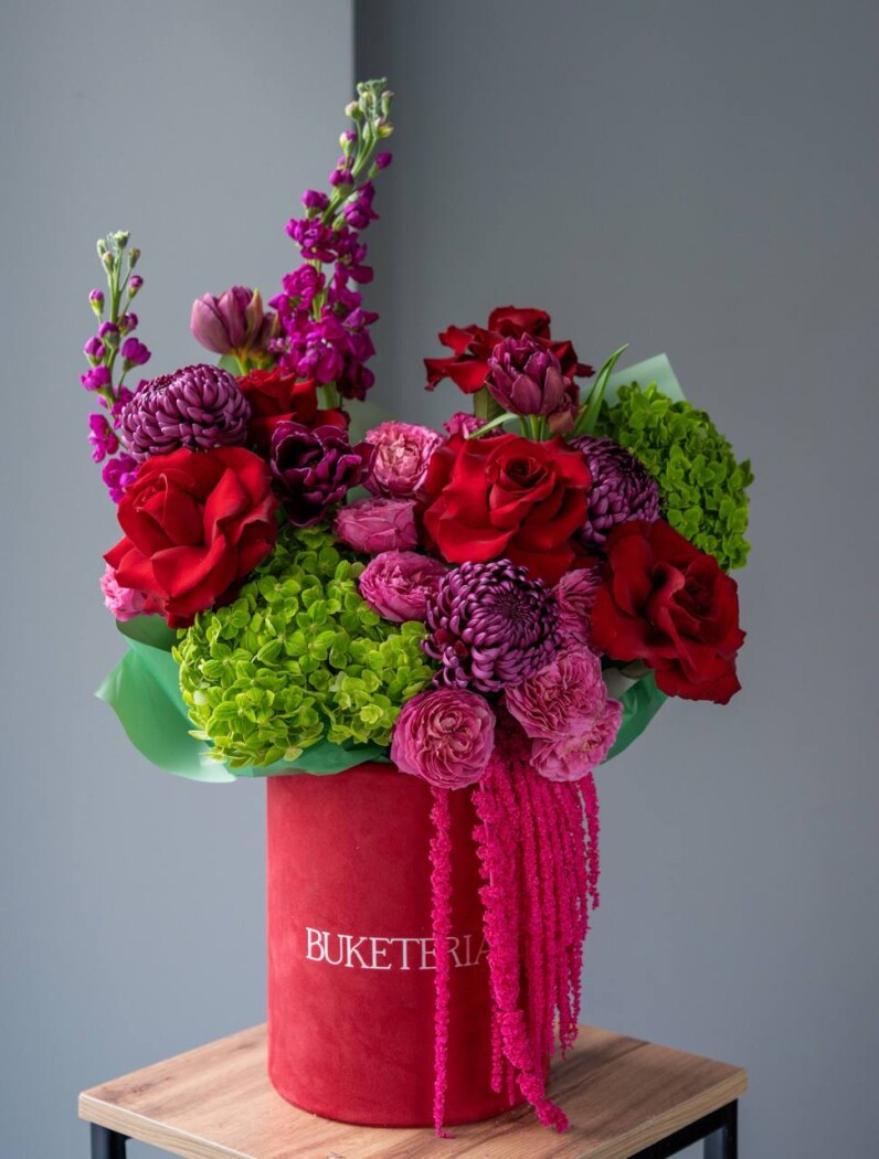 Decorative composition of green hydrangeas and dark red roses