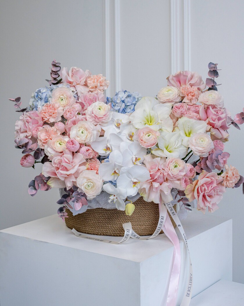 Seventeen blush garden roses with dusty pink ranunculus and light blue hydrangeas