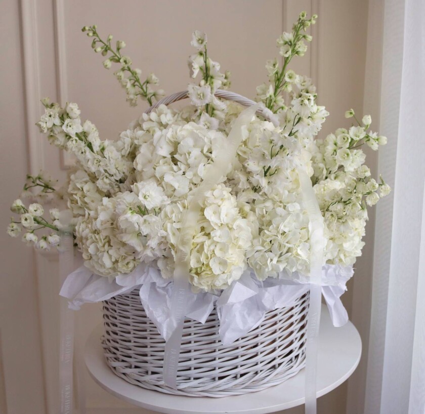 White hydrangeas and delphiniums in a basket