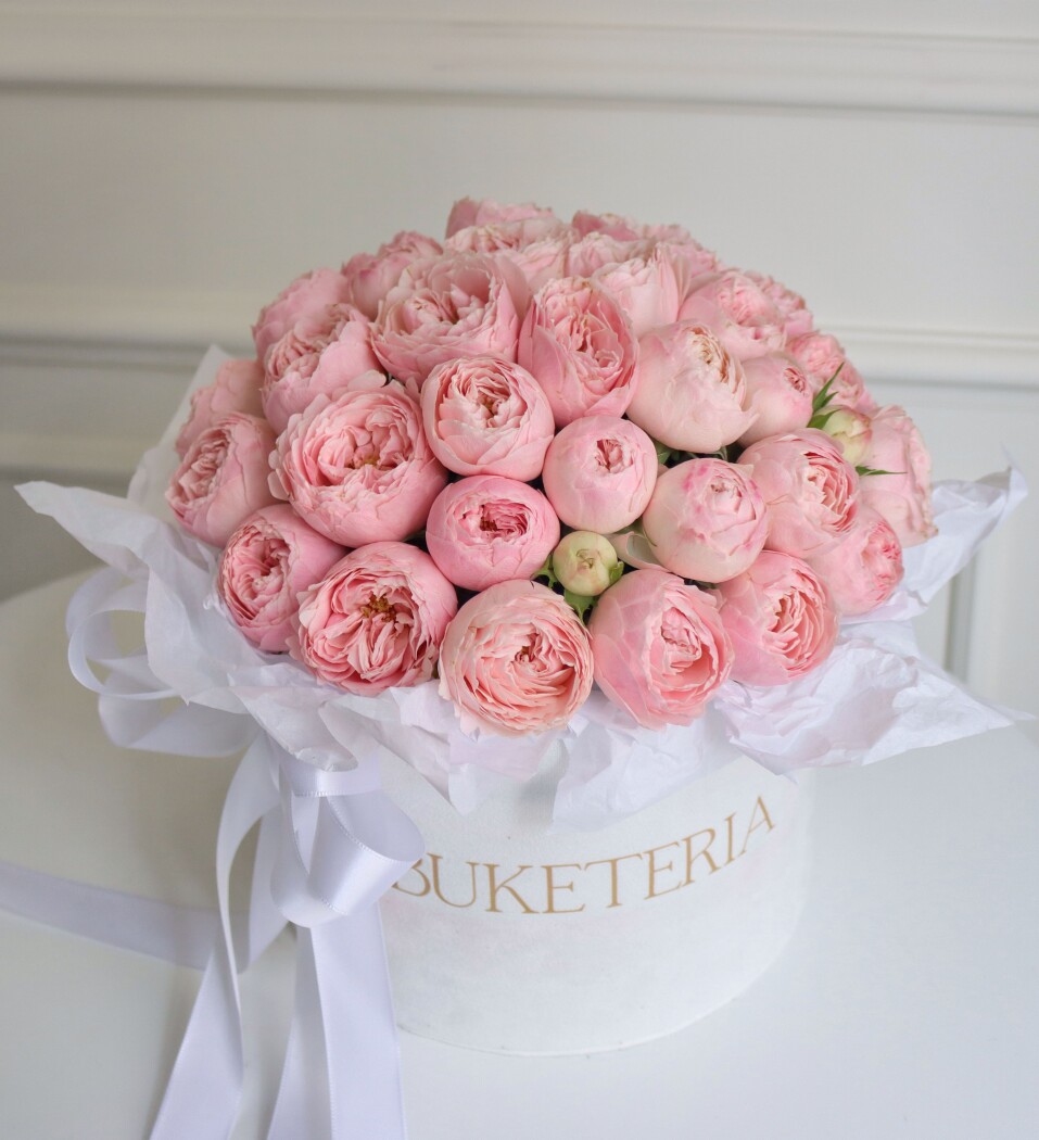 Decorative composition of light pink garden roses in a box
