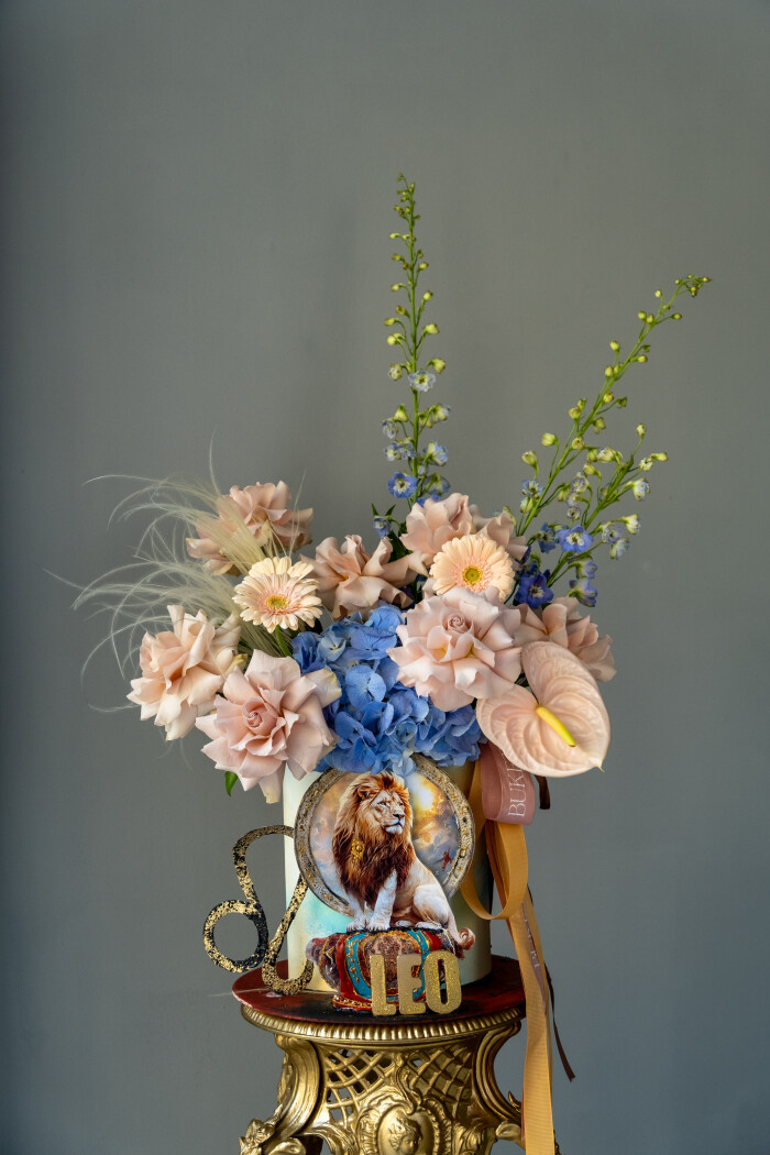 Decorative composition of blush garden roses with blue delphinium