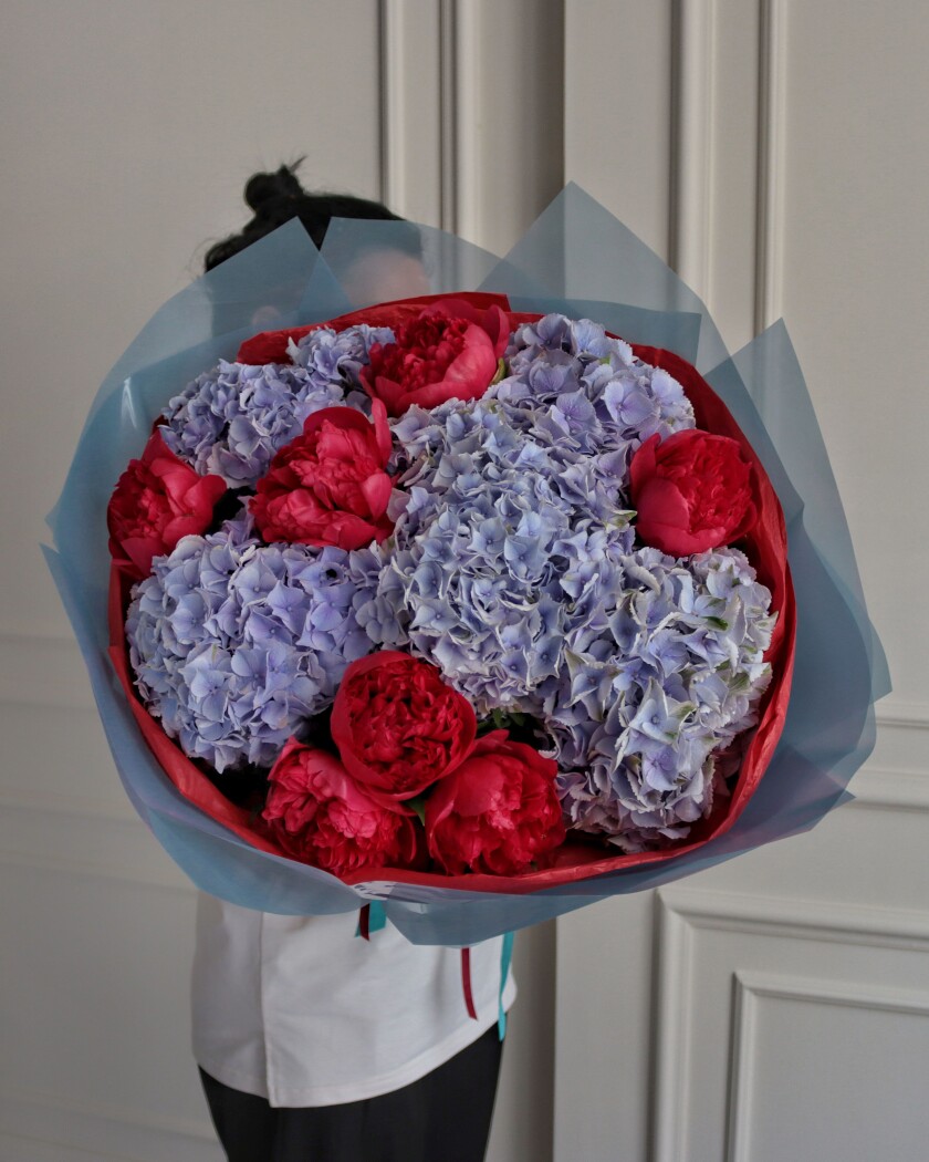 Mixed bouquet of light blue hydrangeas and red peonies