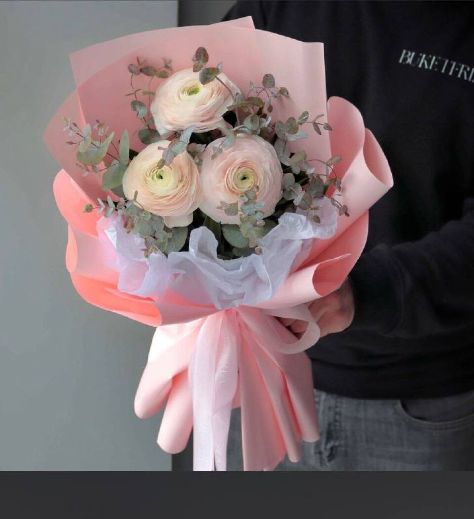 Three cream ranunculus with eucalyptus greenery