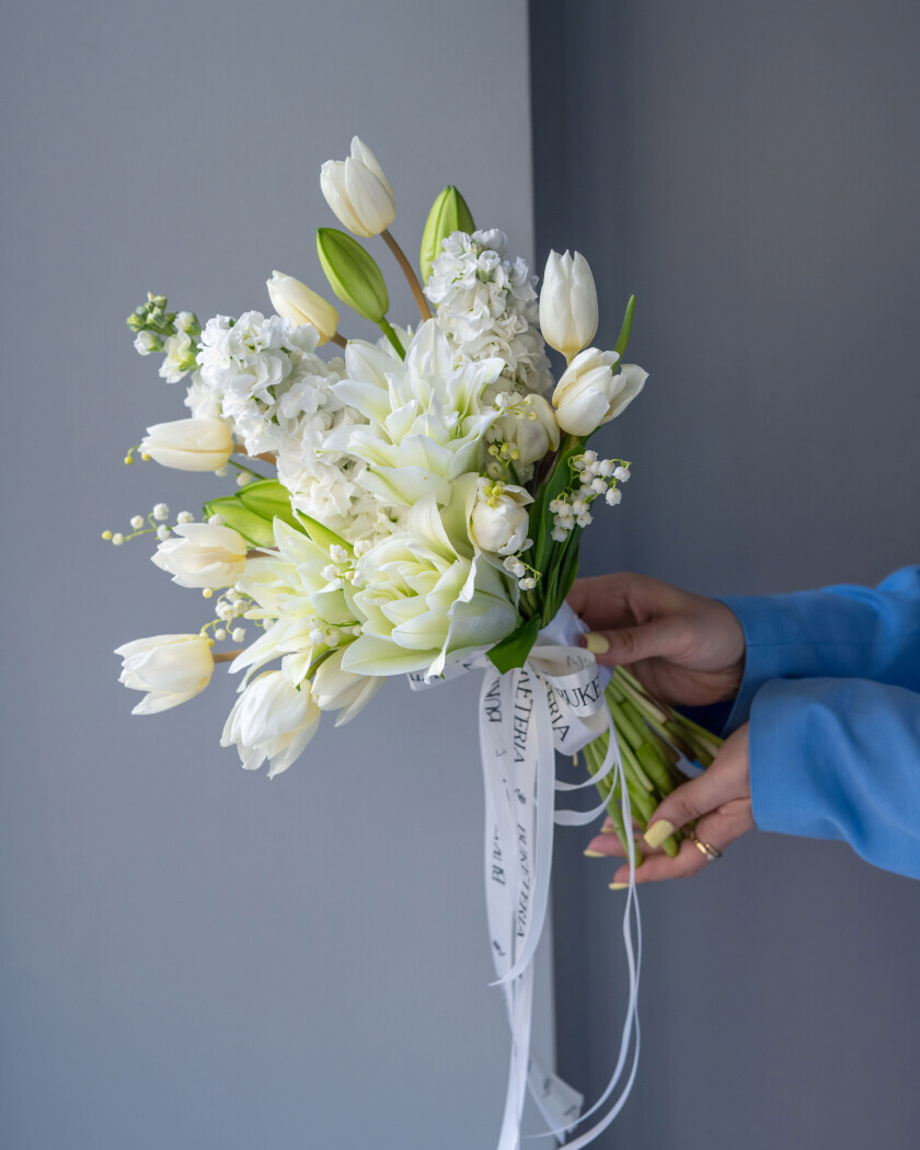 Eleven white tulips and six white lilies of the valley