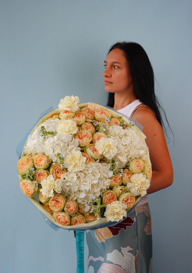 Peach spray roses with white hydrangeas and light blue tweedia
