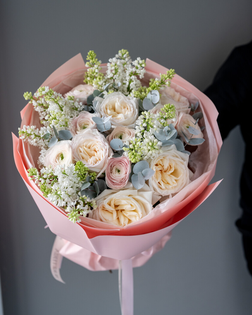 Mixed bouquet of white lilacs, blush ranunculus, and cream garden roses