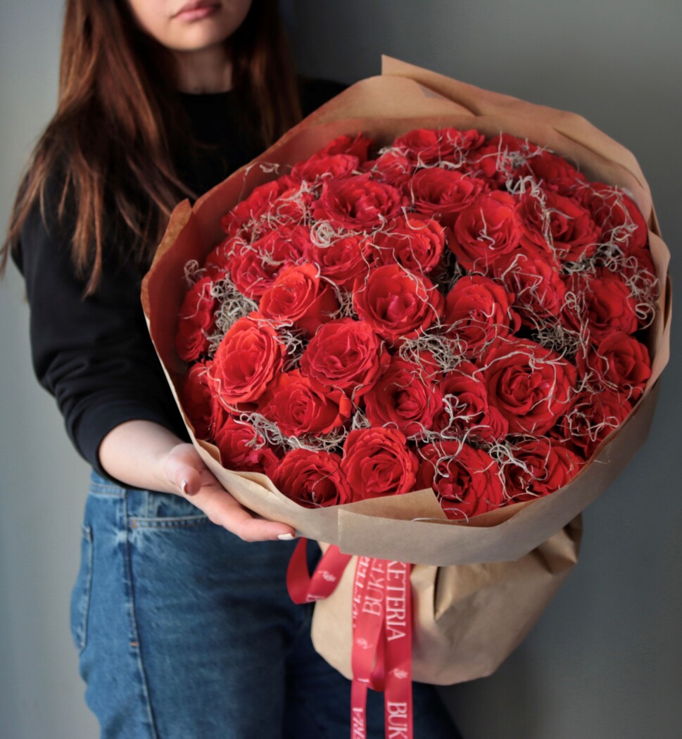 Twenty-five red hybrid tea roses in kraft paper
